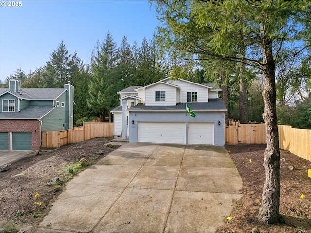 traditional-style house with an attached garage, driveway, a gate, and fence