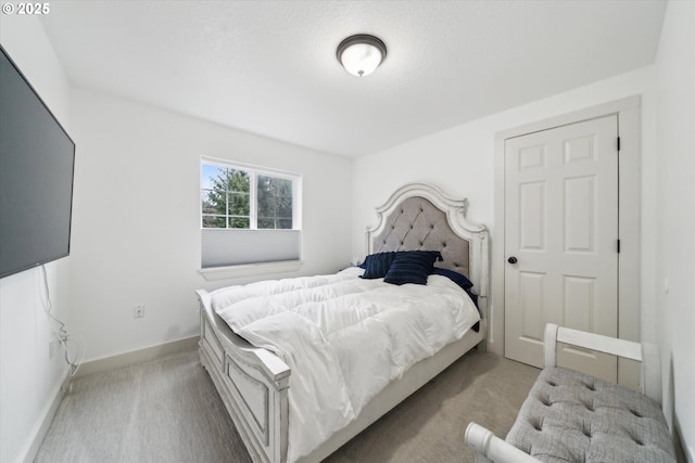 bedroom with light colored carpet and baseboards