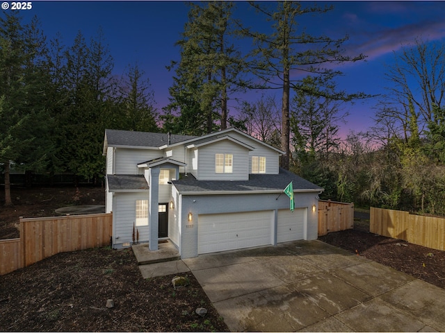 traditional home featuring a shingled roof, concrete driveway, fence, and an attached garage