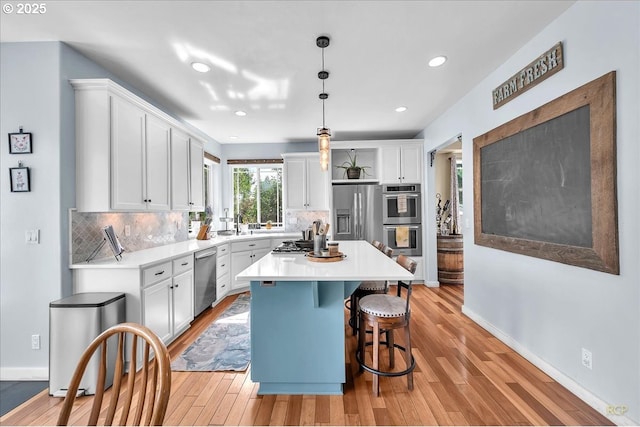 35412 SE Shade Tree Ln, Estacada, OR 97023 - kitchen featuring appliances with stainless steel finishes, white cabinetry, decorative backsplash, a kitchen bar, and recessed lighting