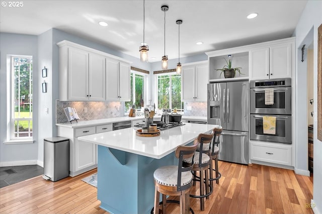 35412 SE Shade Tree Ln, Estacada, OR 97023 - kitchen with appliances with stainless steel finishes, open shelves, light wood finished floors, white cabinets, and recessed lighting