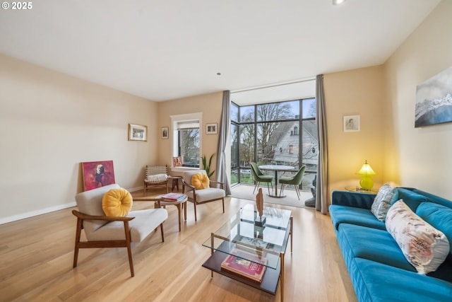 living room featuring baseboards, wood finished floors, and floor to ceiling windows