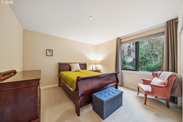 bedroom with baseboards and light carpet