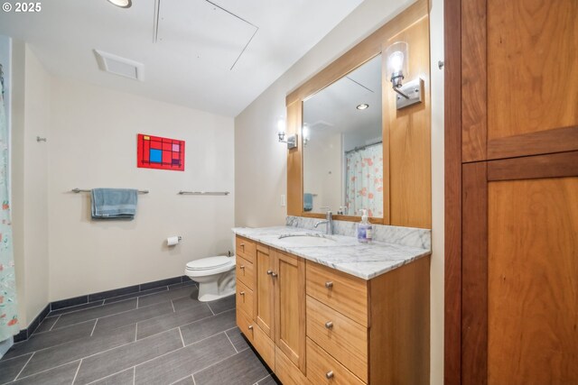 full bath with vanity, toilet, and baseboards