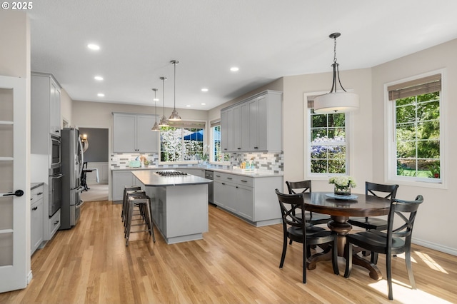 342 NW 84th Pl, Portland, OR 97229 - kitchen featuring gray cabinets, appliances with stainless steel finishes, a kitchen island, plenty of natural light, and recessed lighting