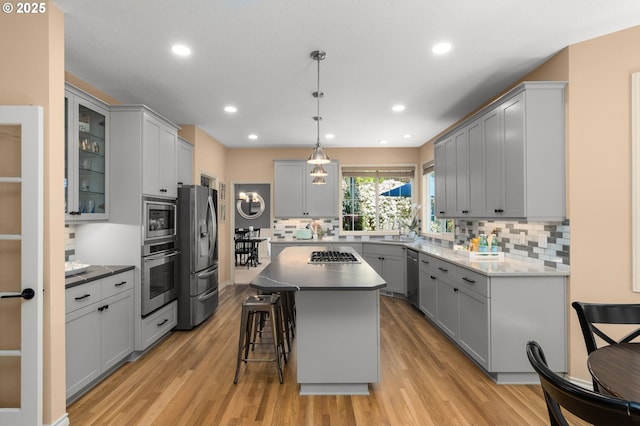 342 NW 84th Pl, Portland, OR 97229 - kitchen with stainless steel appliances, gray cabinetry, light wood finished floors, tasteful backsplash, and recessed lighting