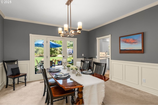 342 NW 84th Pl, Portland, OR 97229 - dining room featuring a chandelier, light colored carpet, crown molding, a wainscoted wall, and a decorative wall
