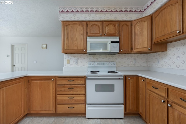 kitchen with brown cabinets, white appliances, light countertops, and a textured ceiling