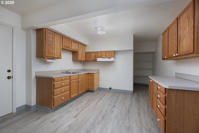 kitchen with light wood-style floors, brown cabinets, and a sink