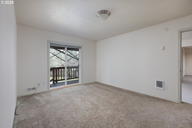 carpeted spare room featuring baseboards and visible vents