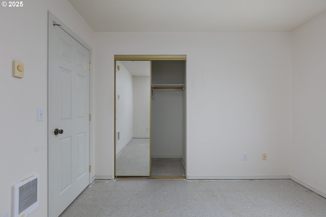 unfurnished bedroom with a closet, baseboards, visible vents, and light floors