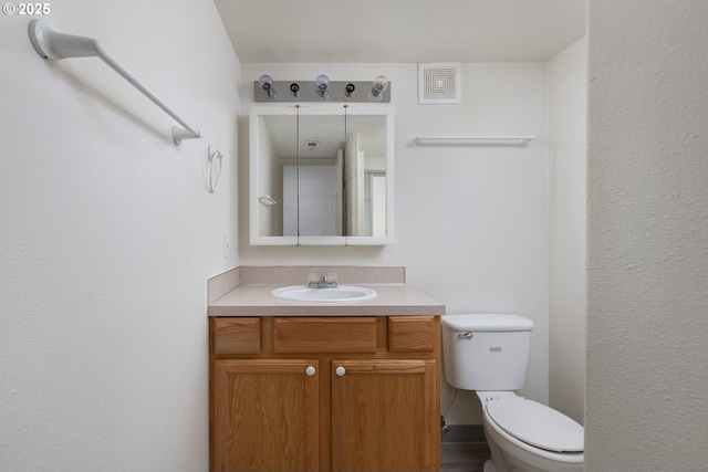 bathroom featuring visible vents, vanity, and toilet