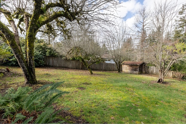 view of yard featuring a fenced backyard, a shed, and an outbuilding