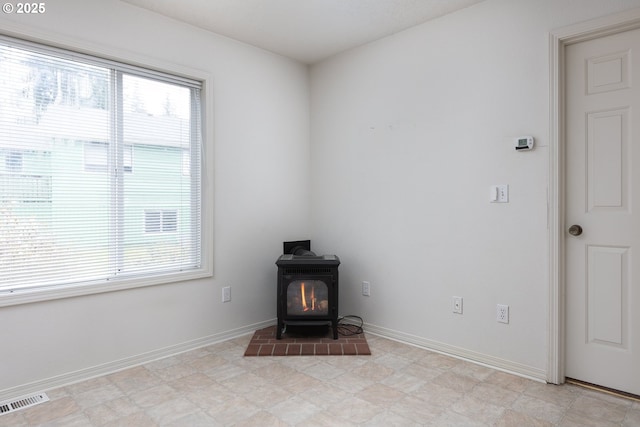 room details with visible vents, a wood stove, and baseboards