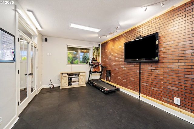 5309 NW 13th Cir, Camas, WA 98607 - workout area with rail lighting, baseboards, brick wall, and french doors
