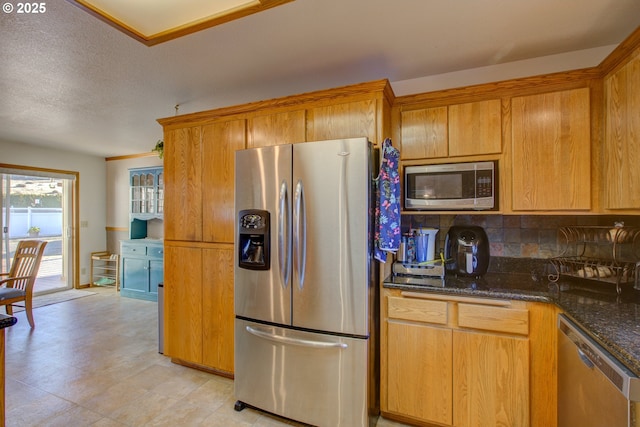 kitchen featuring dark stone counters and stainless steel appliances