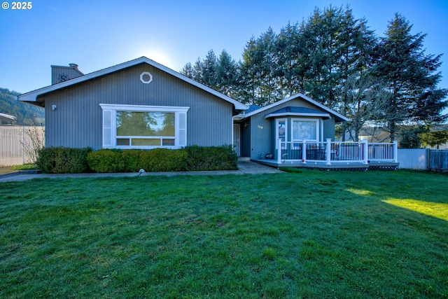 view of front of property featuring a front lawn and a wooden deck