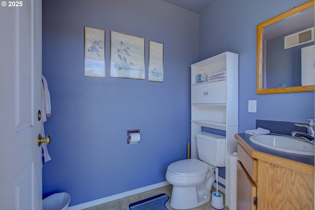 bathroom with toilet, vanity, and tile patterned floors