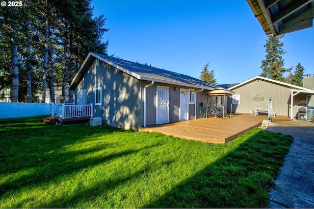 back of property with a deck and a yard