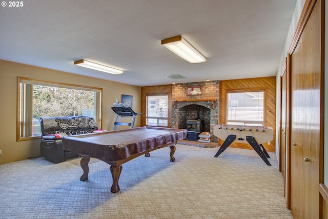 playroom with light carpet, a wood stove, wood walls, and billiards