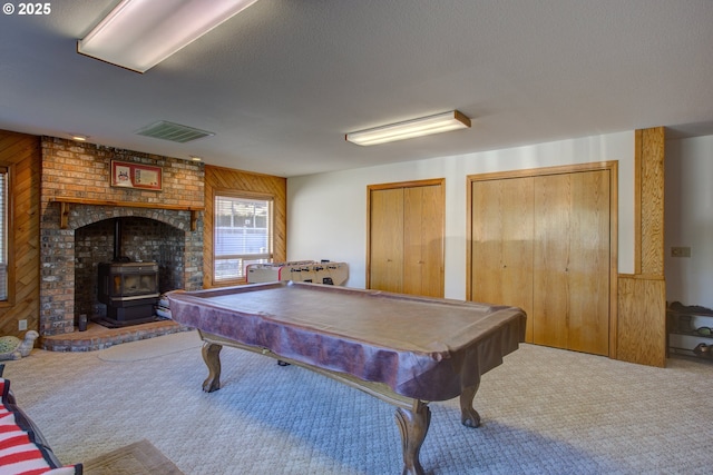 playroom with a wood stove, carpet, billiards, and wooden walls