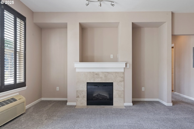 8712 N Decatur St Unit 302, Portland, OR 97203 - unfurnished living room with a wall mounted AC, carpet, a tiled fireplace, and baseboards