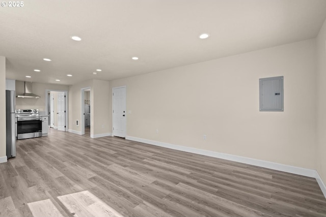 8316 SE Raymond Ct, Portland, OR 97266 - unfurnished living room featuring electric panel, recessed lighting, light wood-style floors, and baseboards