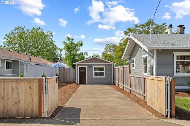 8316 SE Raymond Ct, Portland, OR 97266 - view of property exterior featuring an outdoor structure, a gate, and a shingled roof