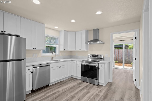8316 SE Raymond Ct, Portland, OR 97266 - kitchen featuring appliances with stainless steel finishes, wall chimney exhaust hood, a sink, light countertops, and recessed lighting