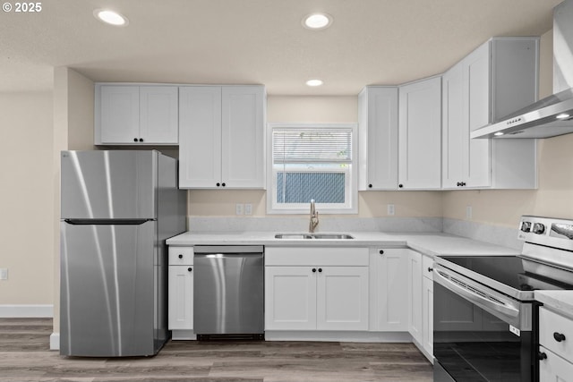 8316 SE Raymond Ct, Portland, OR 97266 - kitchen with stainless steel appliances, wall chimney range hood, a sink, white cabinets, and light countertops