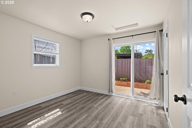 8316 SE Raymond Ct, Portland, OR 97266 - empty room with wood finished floors, baseboards, and attic access