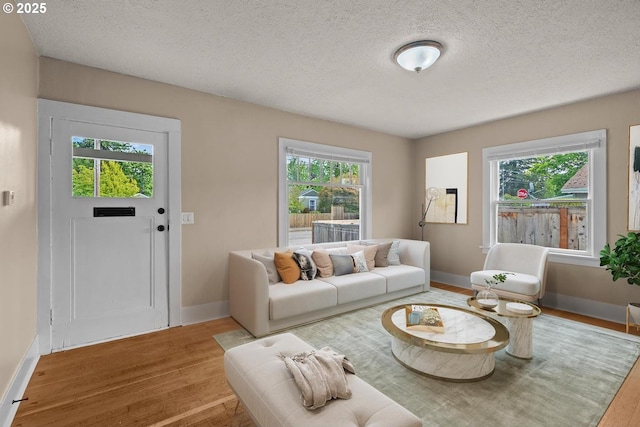 8316 SE Raymond Ct, Portland, OR 97266 - living area with wood finished floors, a textured ceiling, and baseboards