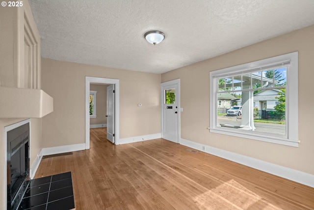 8316 SE Raymond Ct, Portland, OR 97266 - unfurnished living room featuring wood finished floors, baseboards, and a textured ceiling