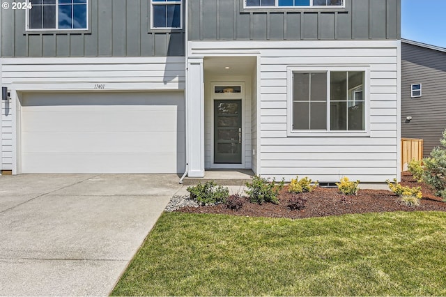 view of exterior entry with a yard and a garage