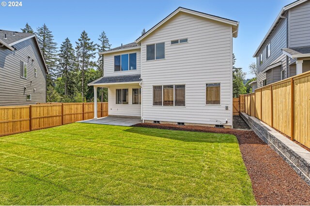 back of property featuring a patio area and a yard