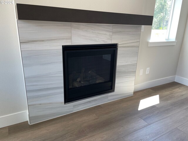 interior details with hardwood / wood-style floors and a tile fireplace