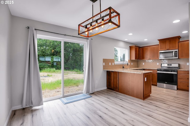 100 Running Dogs Ln, Saint Helens, OR 97051 - kitchen with appliances with stainless steel finishes, a sink, decorative backsplash, brown cabinetry, and baseboards