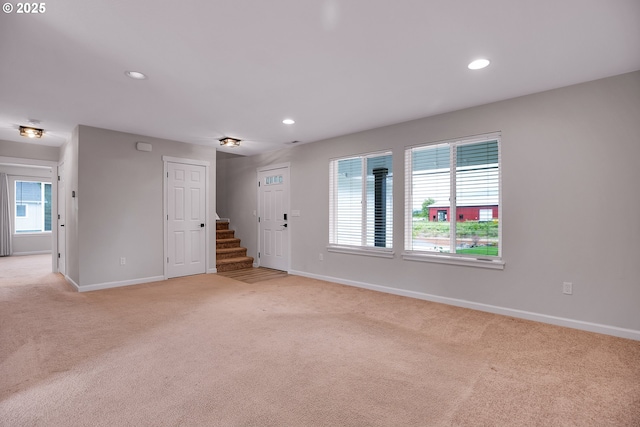 100 Running Dogs Ln, Saint Helens, OR 97051 - unfurnished living room featuring light colored carpet, baseboards, plenty of natural light, recessed lighting, and stairs