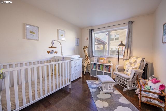 bedroom featuring a crib and wood finished floors