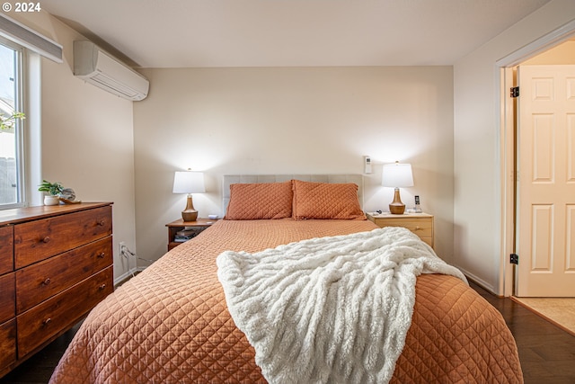 bedroom with baseboards, an AC wall unit, and wood finished floors