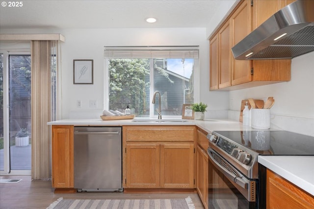5249 NW 173rd Pl, Portland, OR 97229 - kitchen with stainless steel appliances, wall chimney exhaust hood, light countertops, light wood-style floors, and recessed lighting