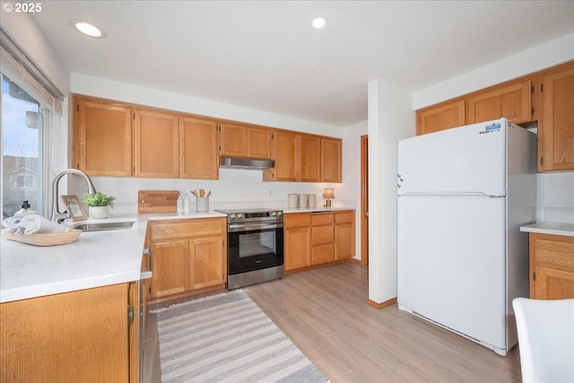 5249 NW 173rd Pl, Portland, OR 97229 - kitchen with freestanding refrigerator, stainless steel range with electric cooktop, under cabinet range hood, light wood finished floors, and light countertops