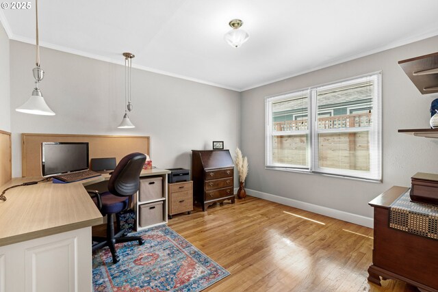 home office featuring light wood-style floors, ornamental molding, and baseboards