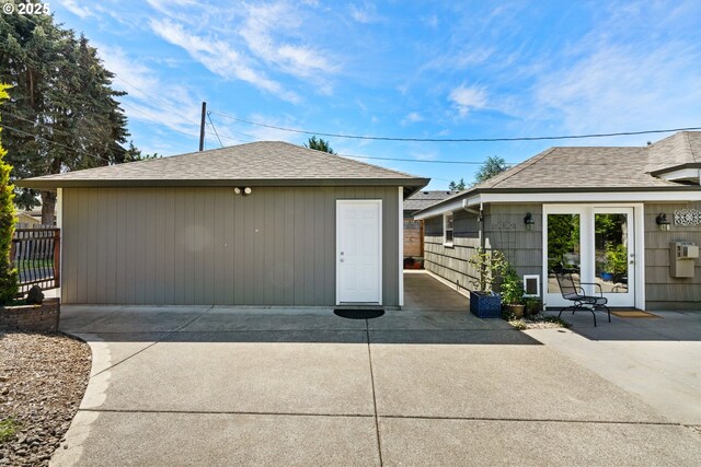 exterior space with a patio, an outdoor structure, fence, and roof with shingles