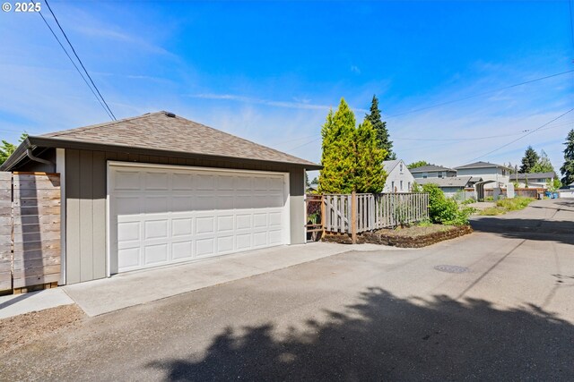 detached garage featuring fence