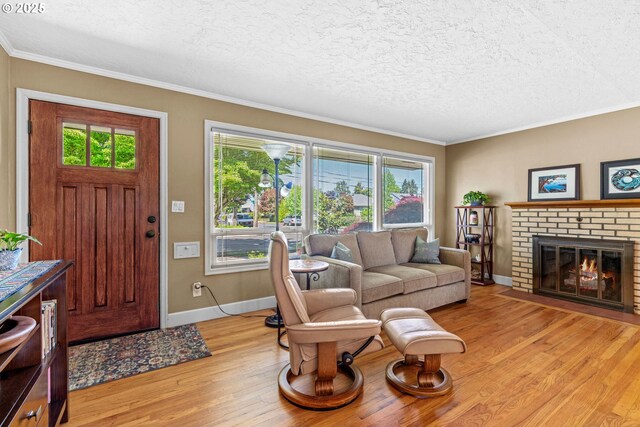 living area featuring light wood-style floors, healthy amount of natural light, baseboards, crown molding, and a textured ceiling