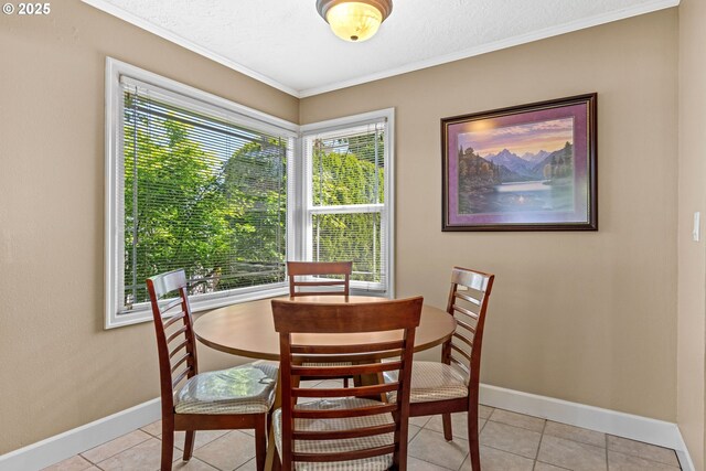 dining room with baseboards, ornamental molding, and light tile patterned flooring