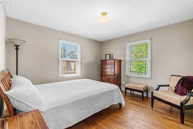 bedroom featuring light wood-type flooring and baseboards
