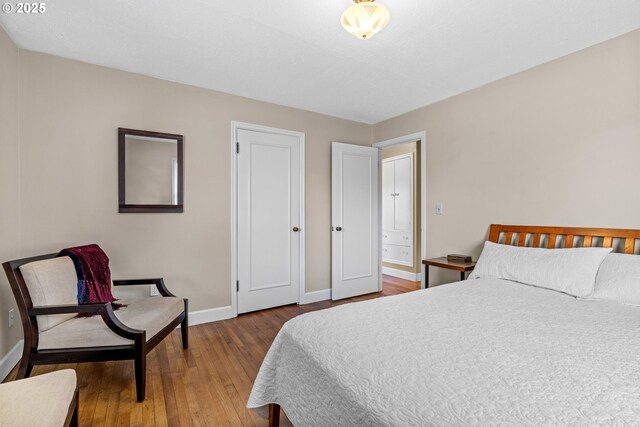 bedroom with baseboards and wood finished floors