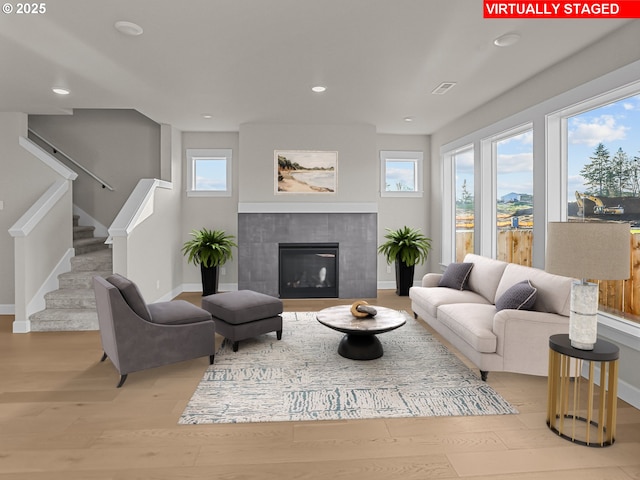 living room with a fireplace and light wood-type flooring